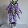 Purple artificial wisteria mini tree in white pot.