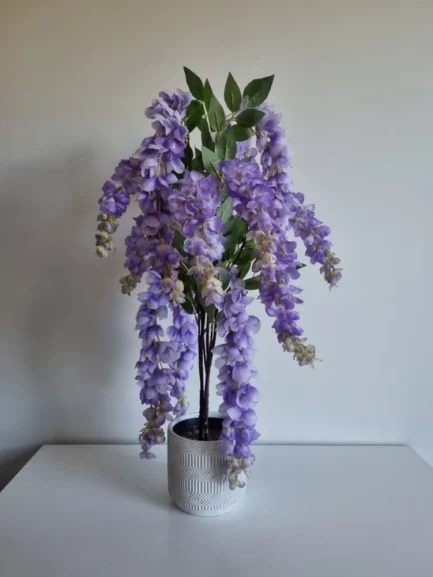 Purple artificial wisteria mini tree in white pot.